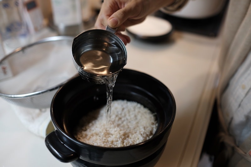 土鍋にお米を移して水を加える様子